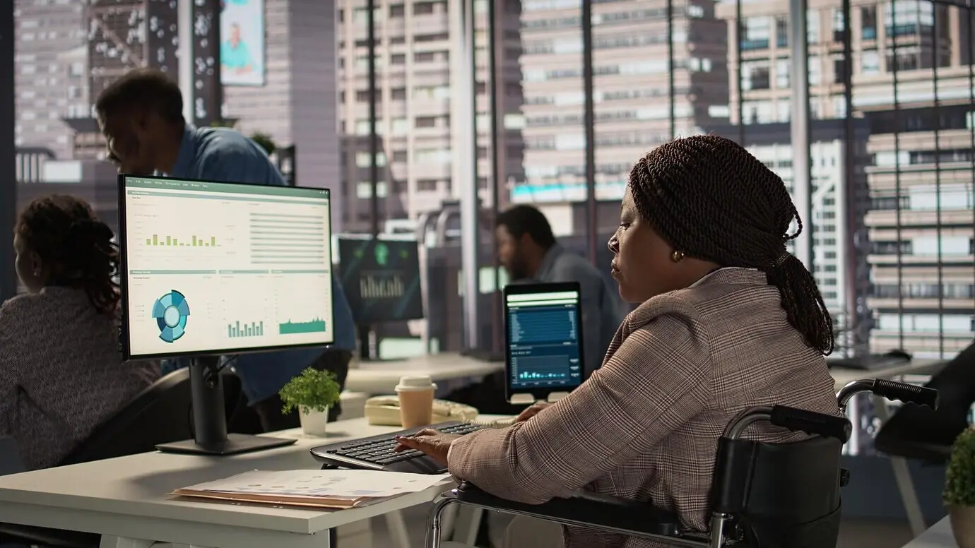 Женщина-руководитель с хронической инвалидностью изучает архивные файлы и отчеты по данным.