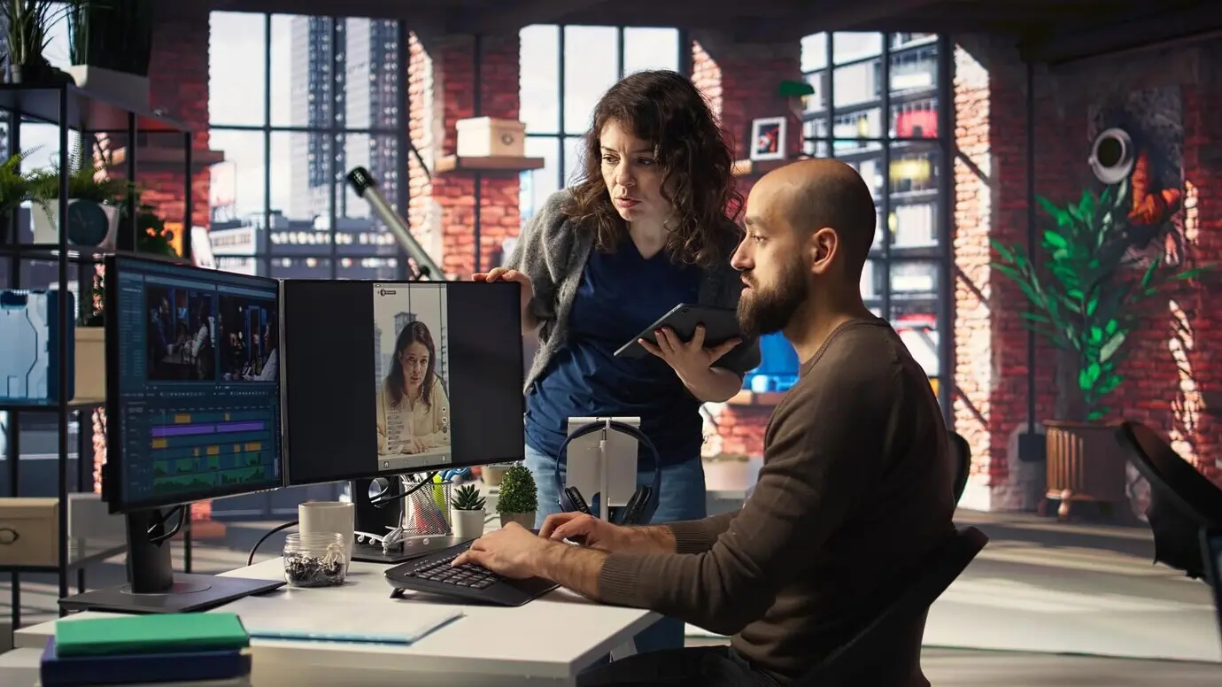 Профессиональный редактор в креативном офисе использует программное обеспечение на базе ИИ и ПК, работая с рилсами.